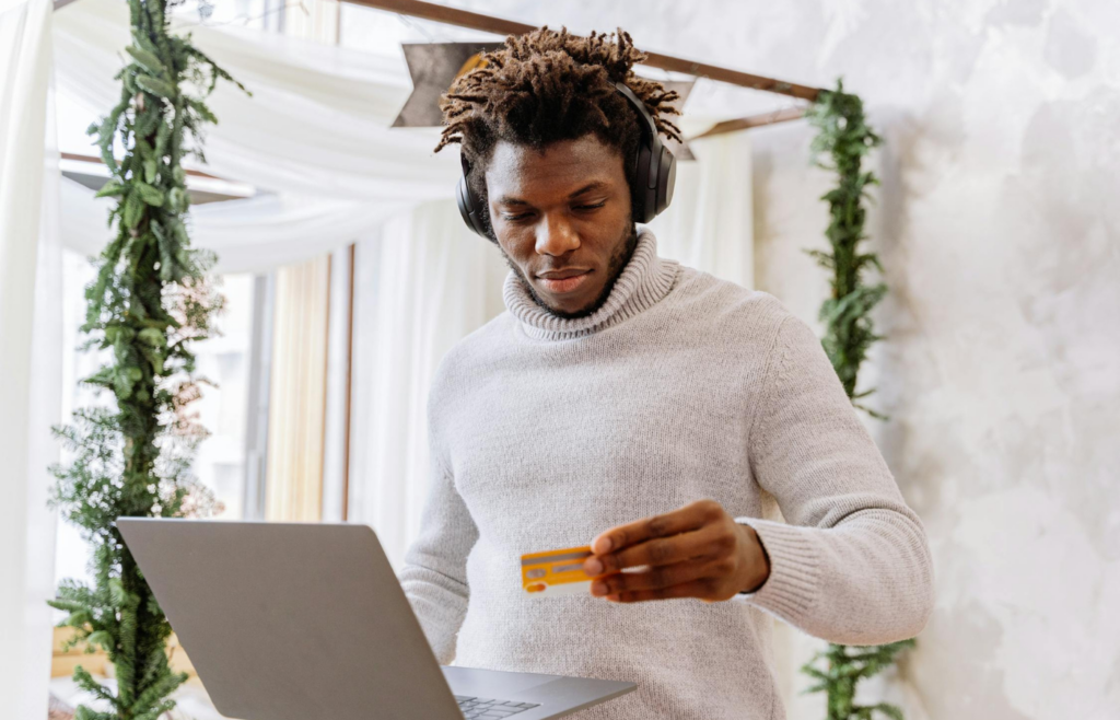 A person holding a credit card while looking at a stock trading app