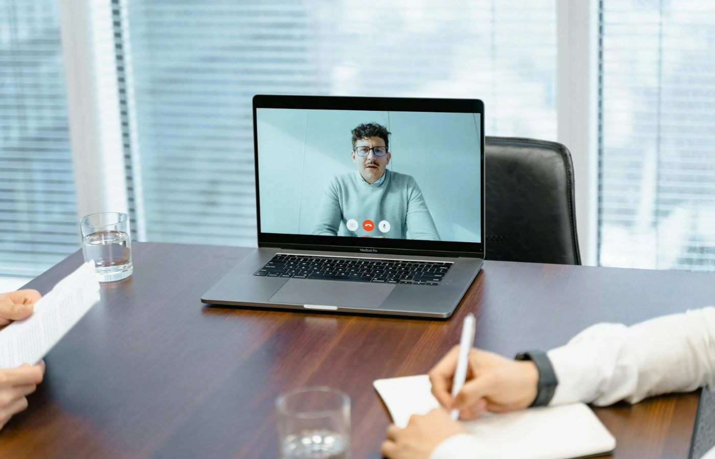 A person watching a financial expert on a TV or laptop.