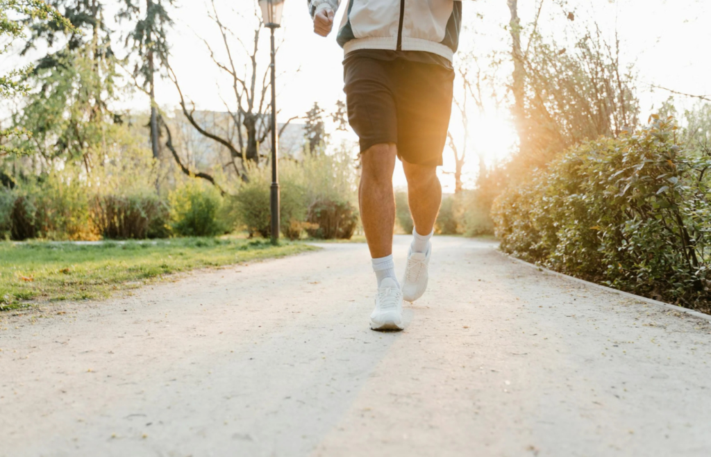 An individual jogging in a park during sunrise