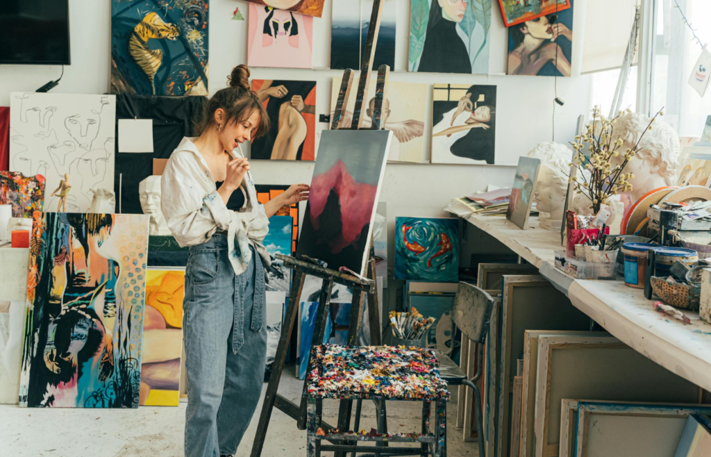 Someone painting on a canvas in a home studio