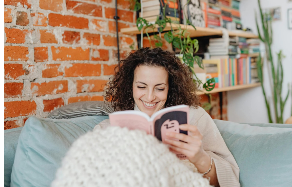 An individual reading a book in a cozy nook