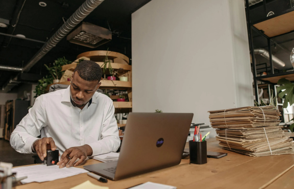 An employee repeatedly stamping documents with a bored expression