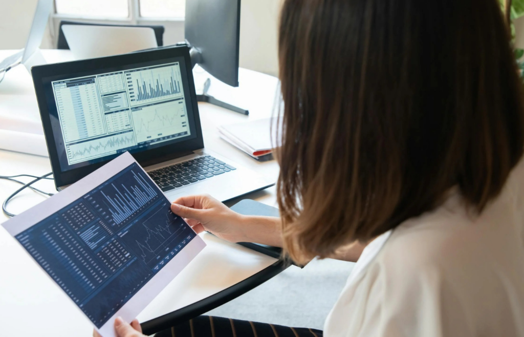 A person reviewing investment charts on a laptop