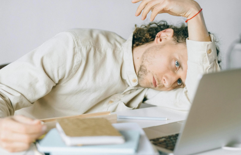 An employee looking fatigued and stressed at their desk