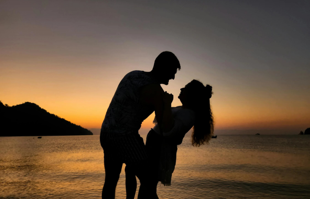 An elderly couple enjoying a sunset on the beach