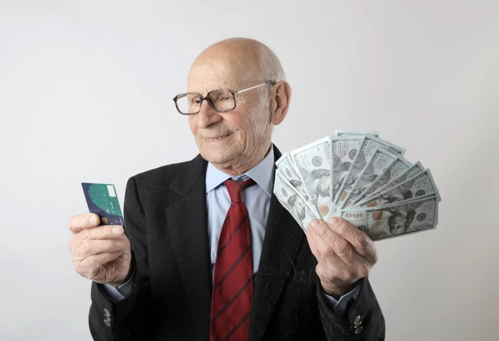 Man In black suit holding banknotes and credit card