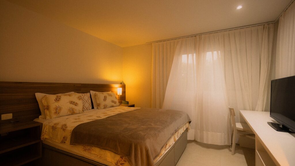 A hotel room with a bed and television.