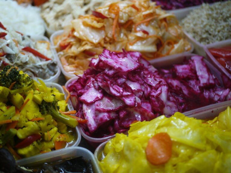 Assortment of colorful pickled vegetables in containers.