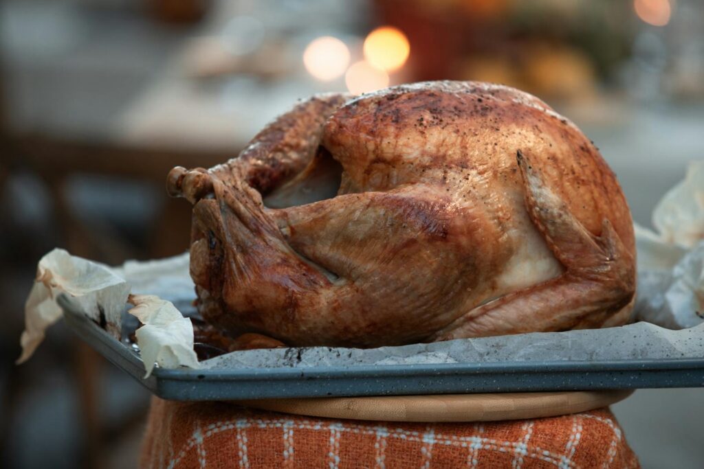 A perfectly roasted whole turkey on a tray, ready for Thanksgiving dinner.