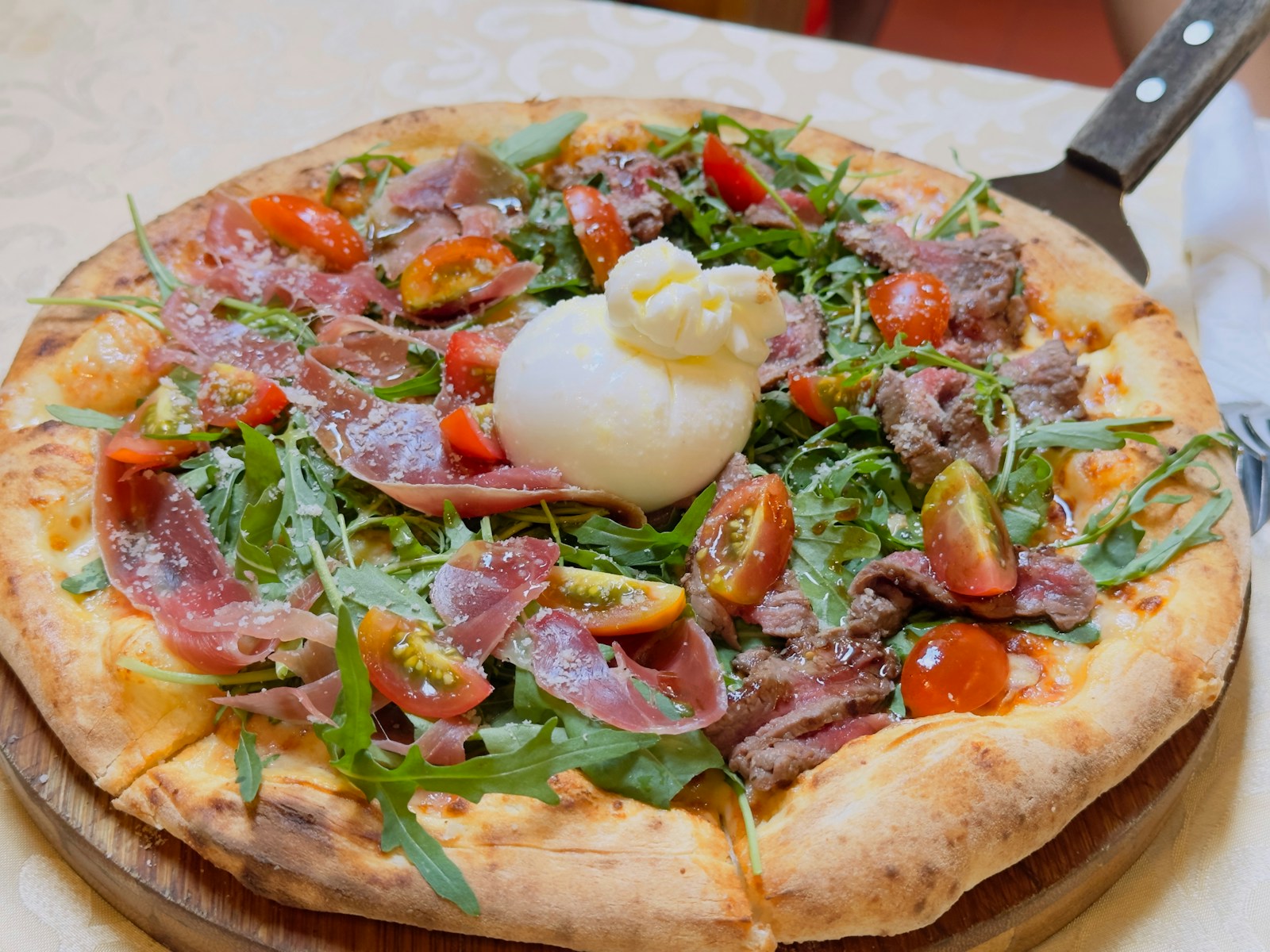Gourmet pizza with burrata and fresh toppings.