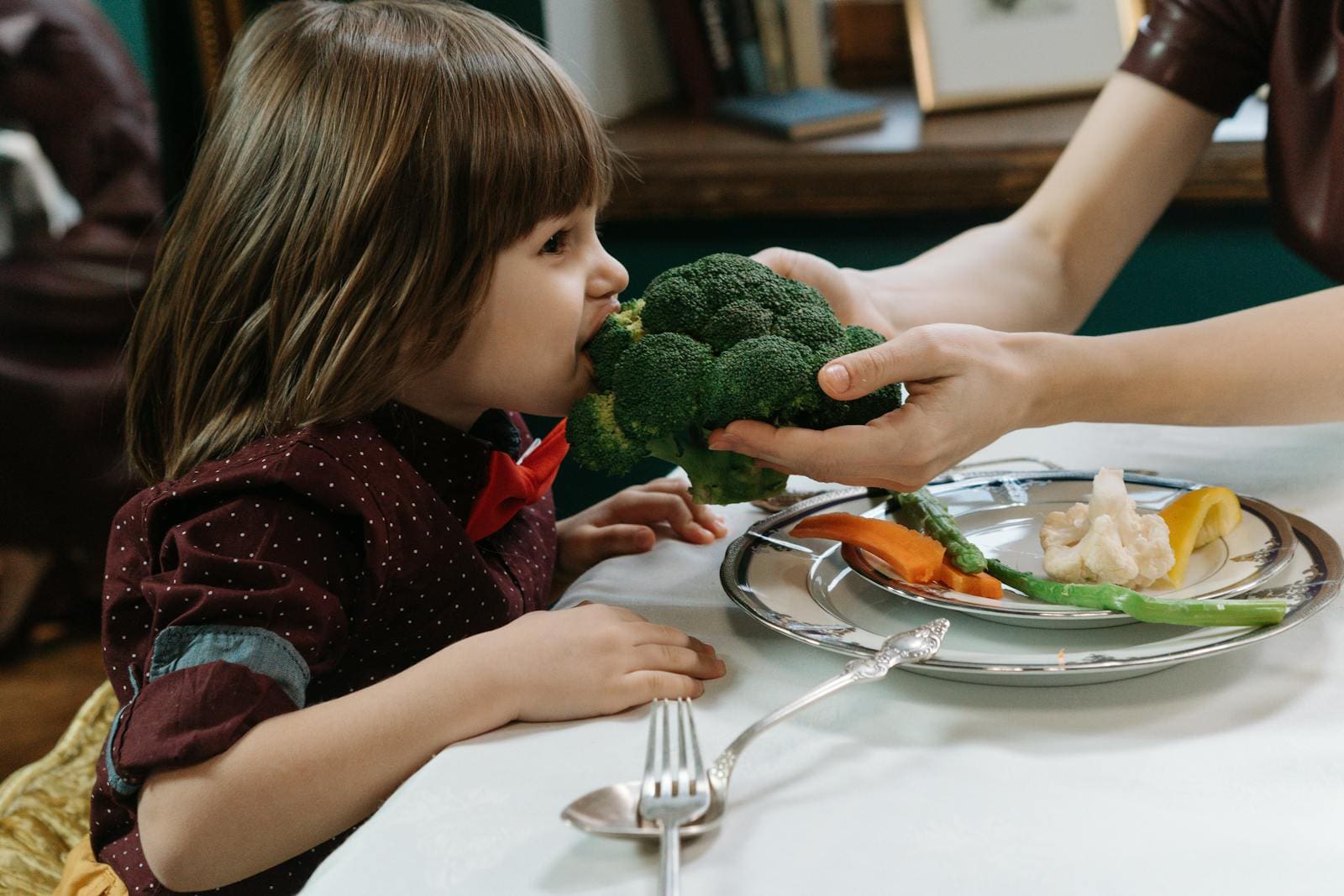 little girl eating broccoli
