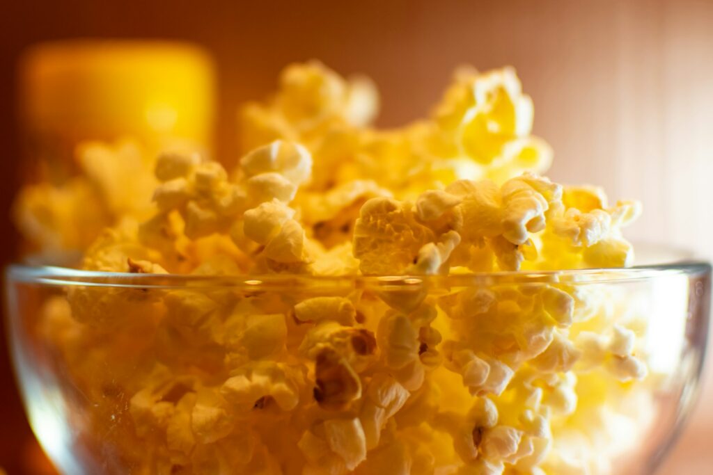 A glass bowl filled with popcorn sitting on top of a table