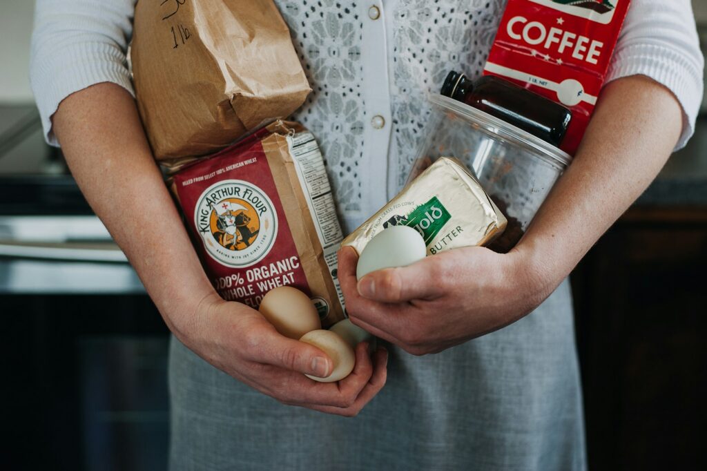 a person holding a bag of food and a cup of coffee