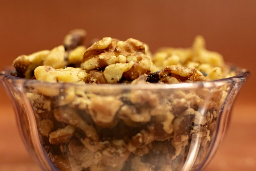 A glass bowl filled with granola on top of a wooden table