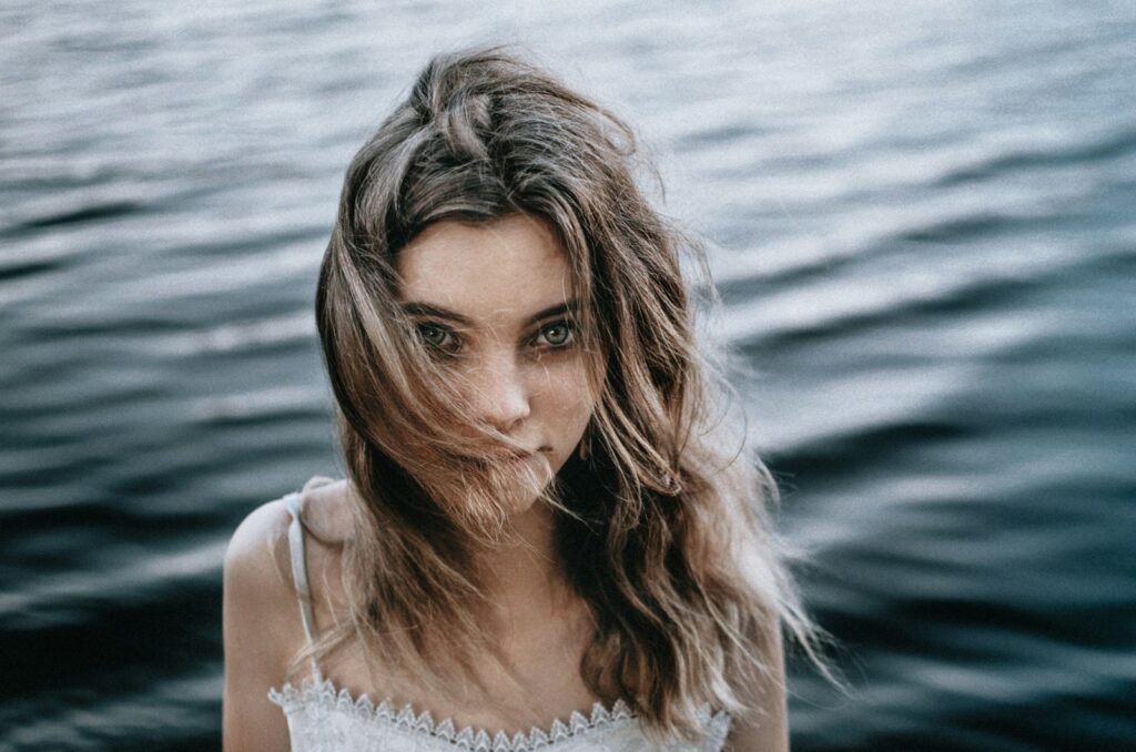 a woman standing in front of a body of water