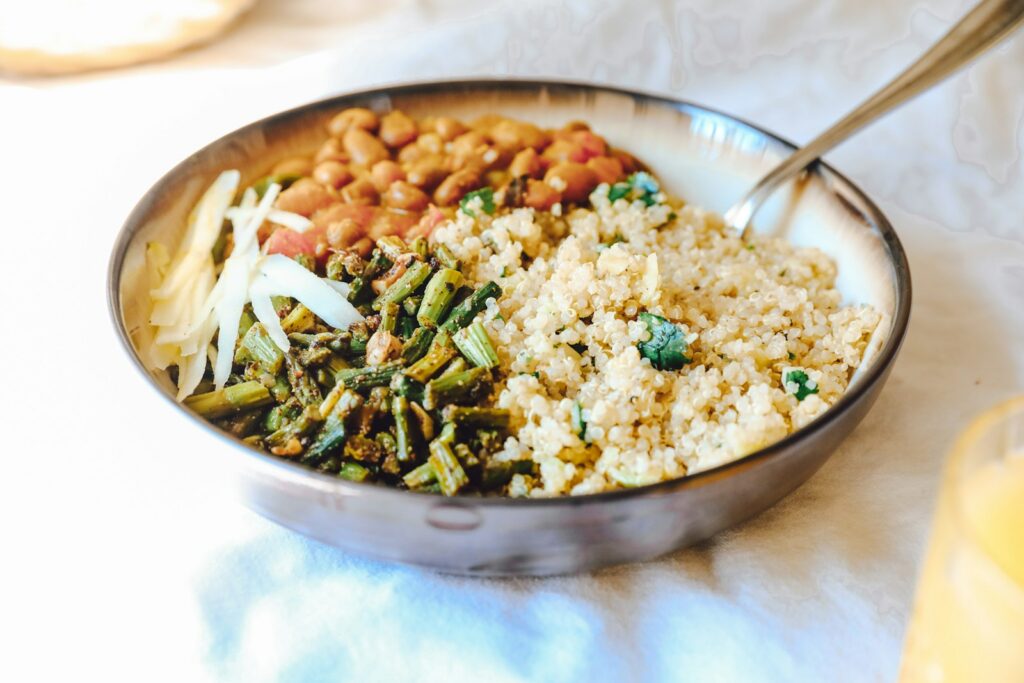 quinoa with green peas and carrots on stainless steel bowl