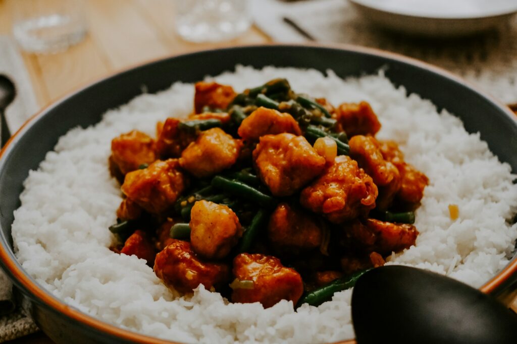 a bowl filled with rice and meat on top of a table