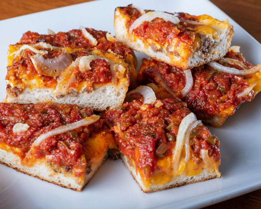 Slices of pizza with tomato sauce and onions