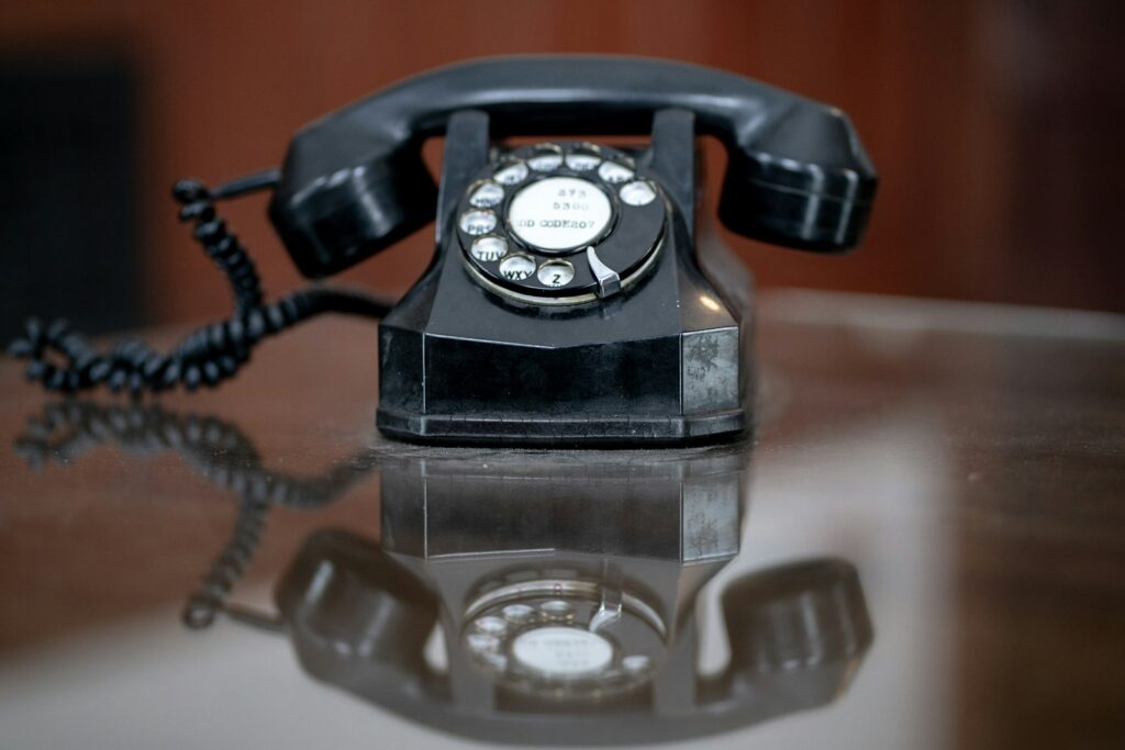 black rotary phone on brown wooden table