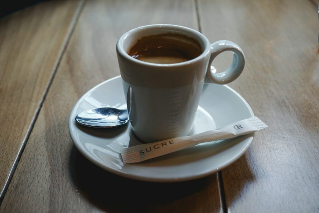 A cup of espresso with sugar and spoon.