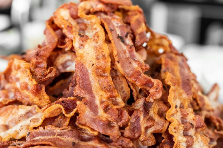 A heap of crispy cooked bacon strips on display, showcasing delicious texture and color.
