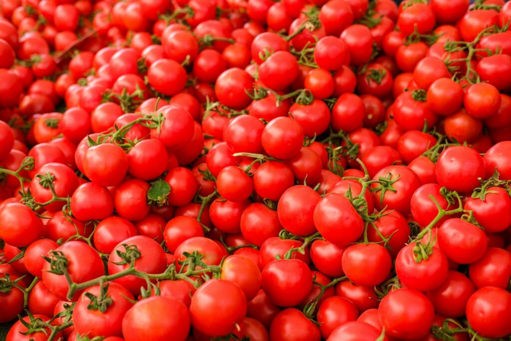 Vibrant and fresh red tomatoes piled in abundance, perfect for culinary and agricultural themes.