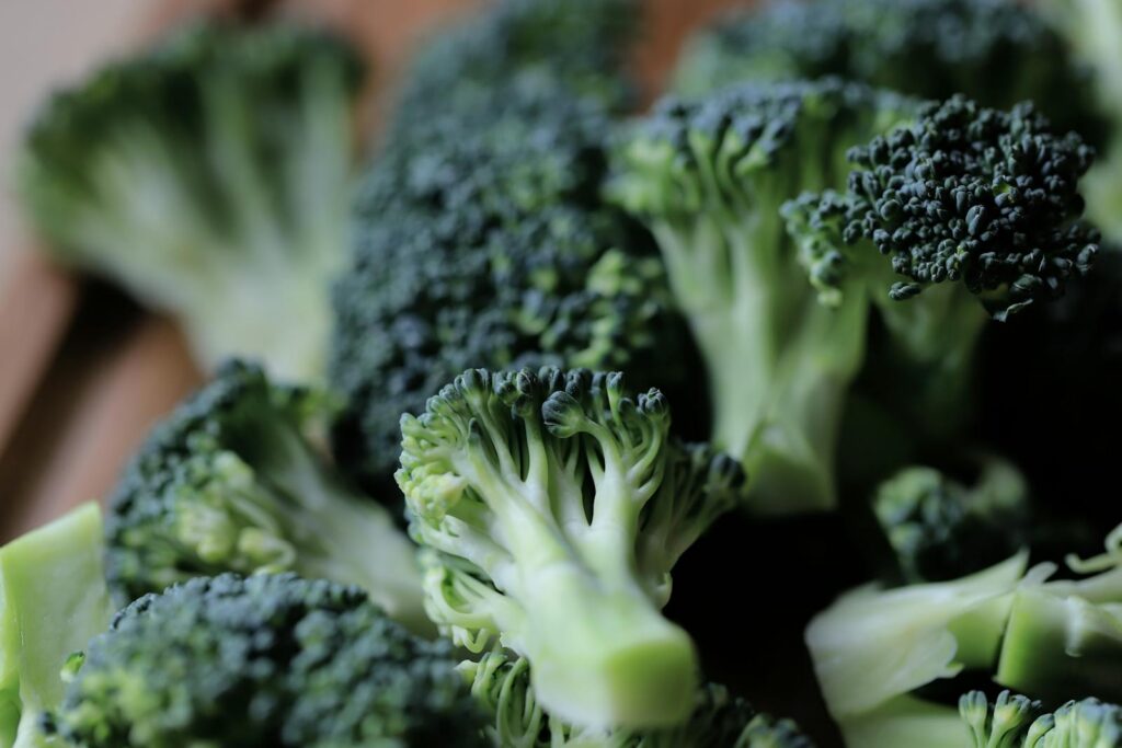 Close-up of fresh green broccoli florets on a kitchen chopping board, ready for cooking.