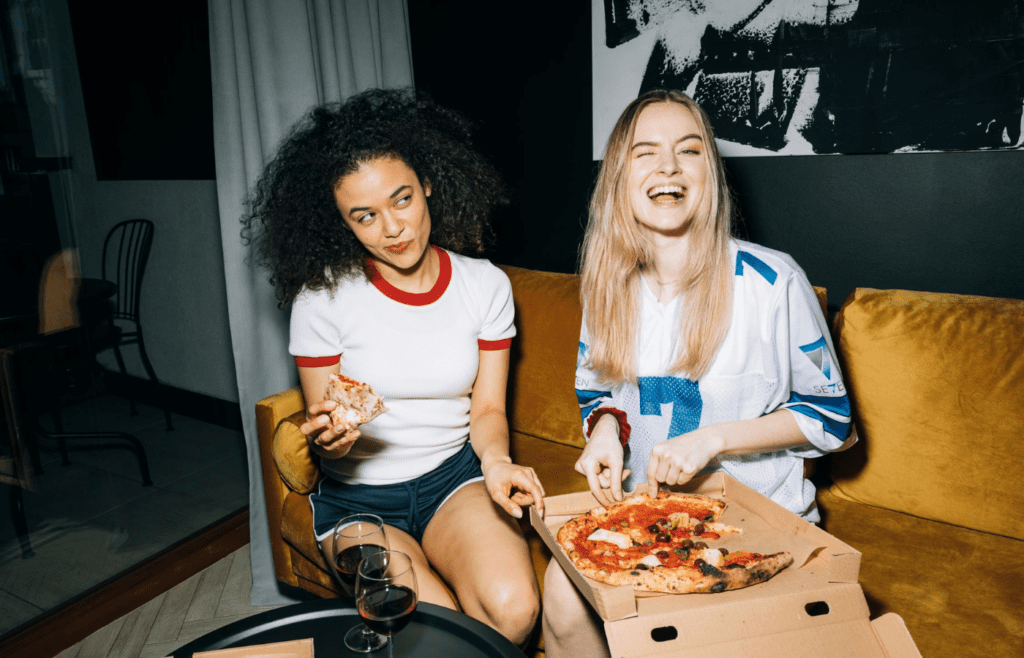 two woman eating pizza