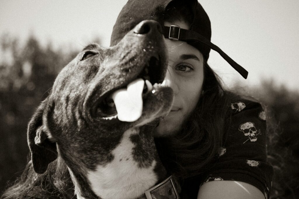 grayscale photo of woman beside dog