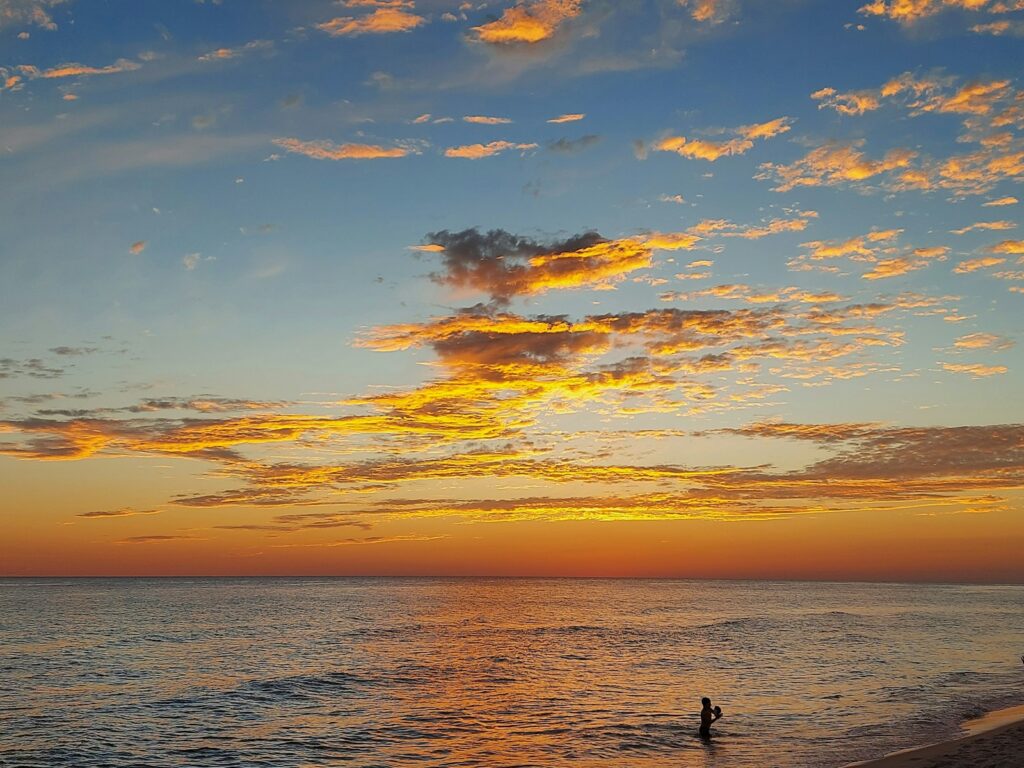 a person standing on a beach next to the ocean