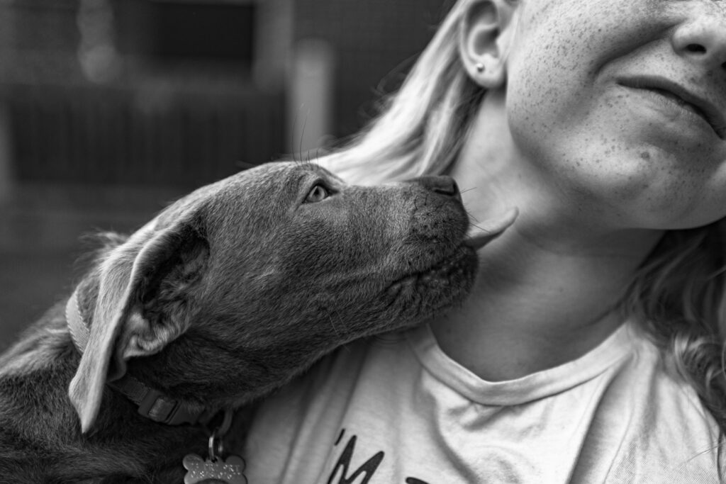 A black and white photo of a woman holding a dog