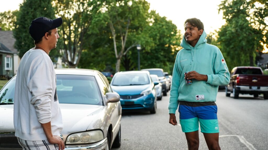 man in green hoodie standing on road during daytime
