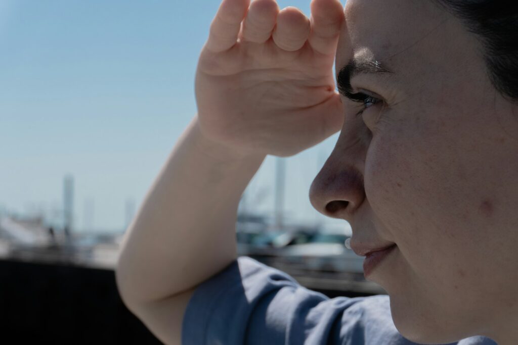 A person shields their eyes from the sun.