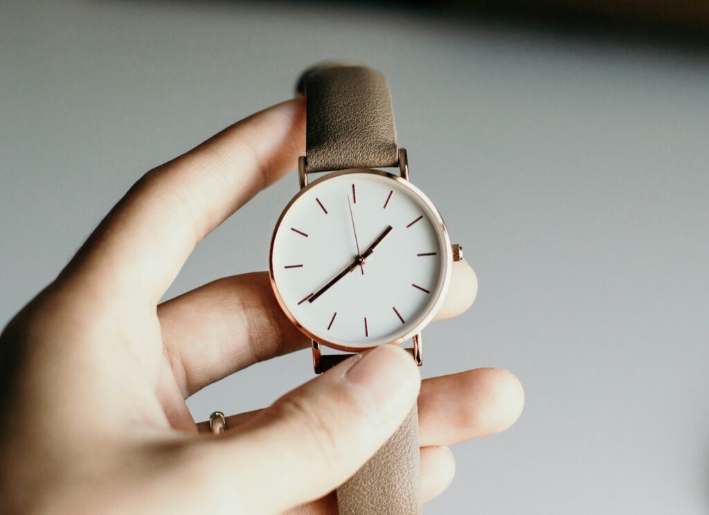 person holding analog watch