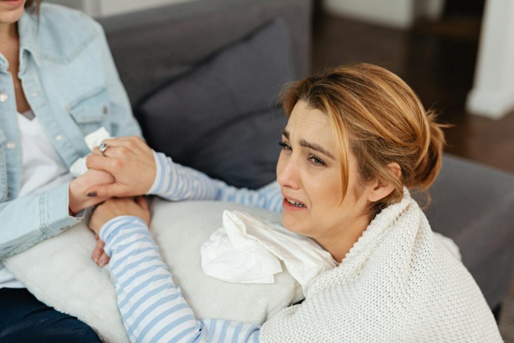 A crying woman is comforted by a friend, showcasing emotional support and empathy.