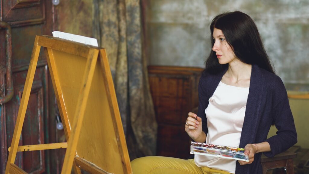 Woman painting on an easel with watercolors.