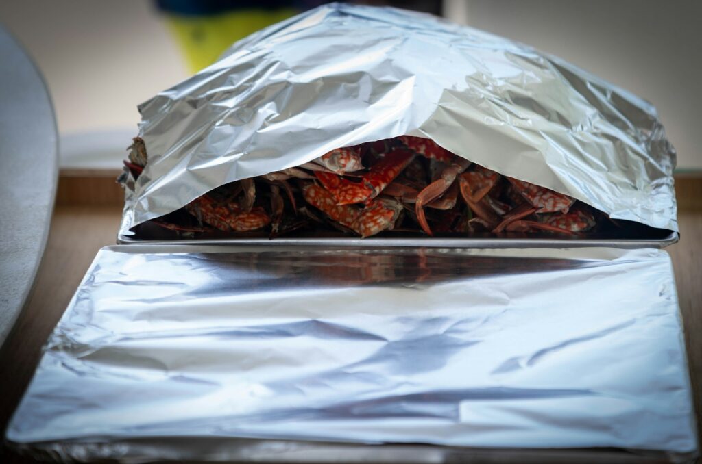 Tray of cooked crawfish covered with foil