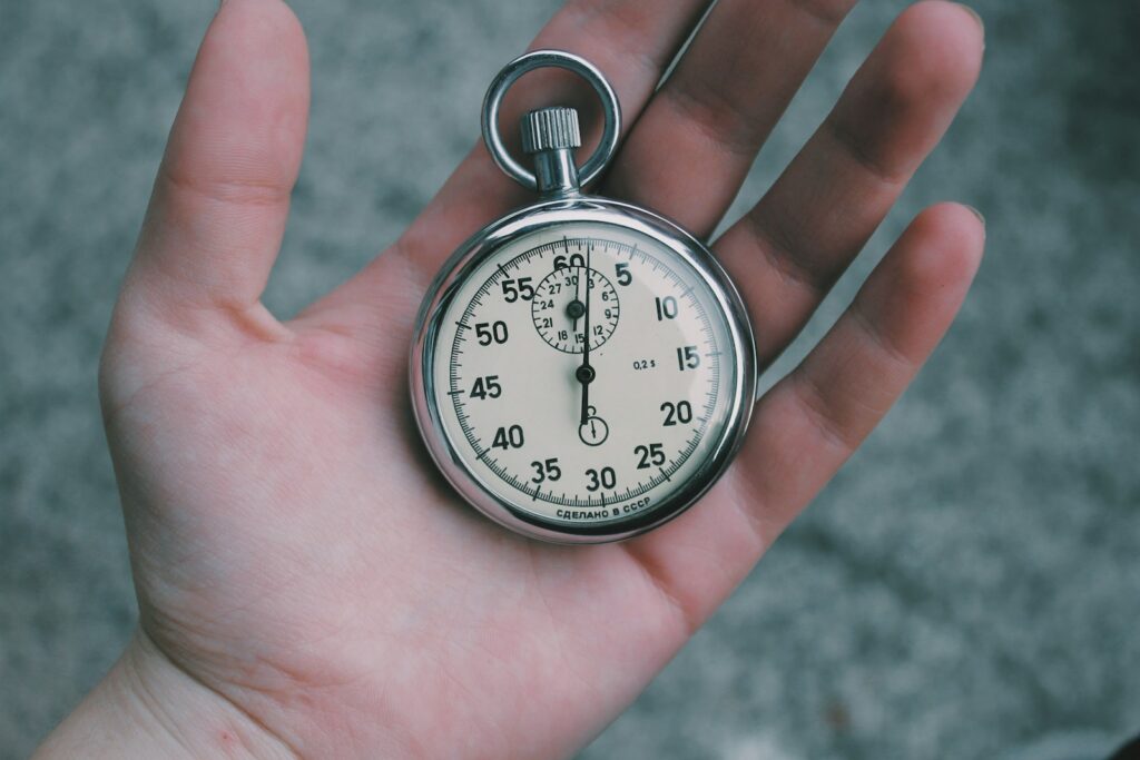 person holding white and silver-colored pocket watch