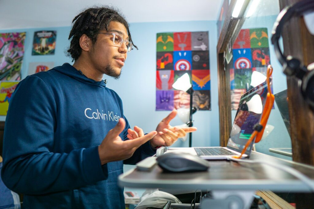 man in blue crew neck t-shirt holding smartphone