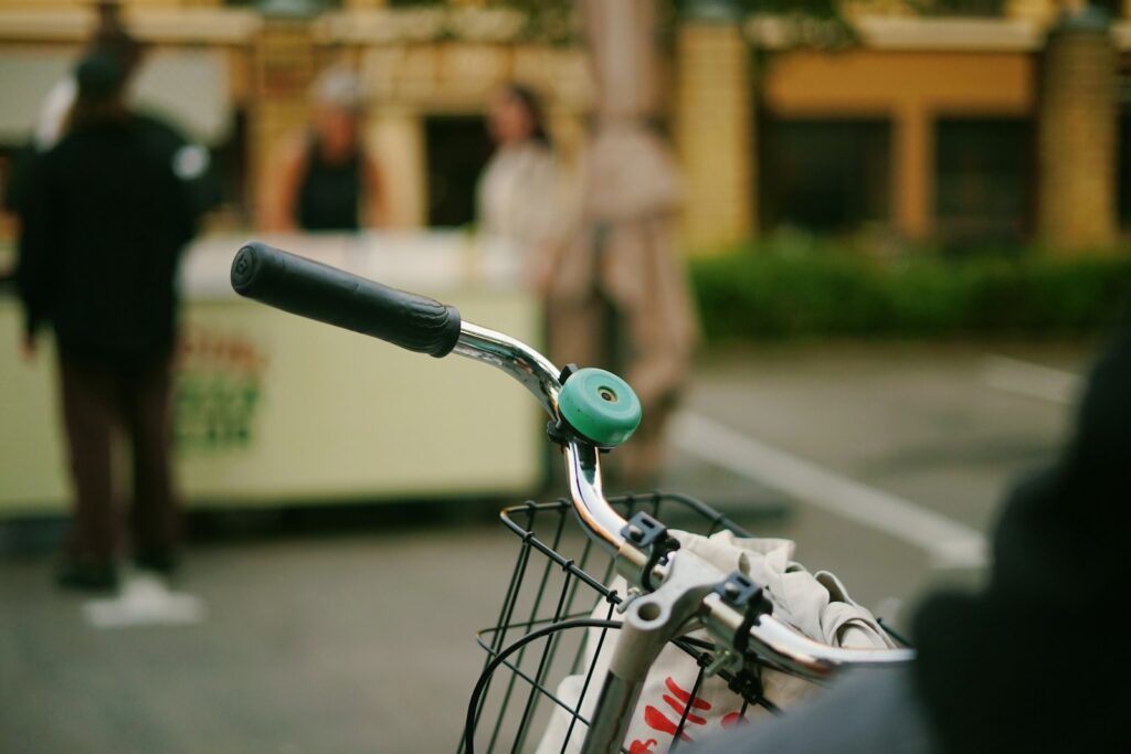 Close-up of a bicycle handlebar with a green bell.