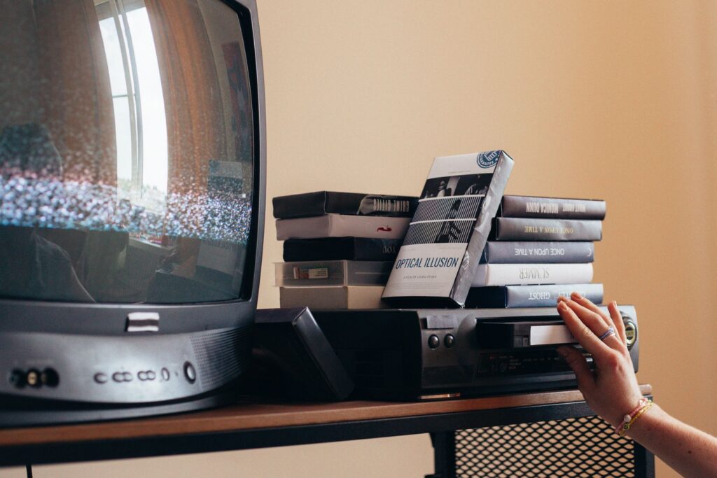 Vintage scene with a VHS player, tapes, and an old CRT TV creating a nostalgic vibe.