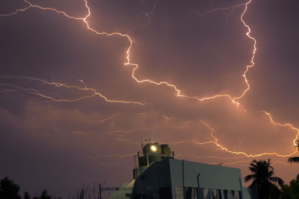 Captivating night view of a powerful lightning storm illuminating the sky above a building.