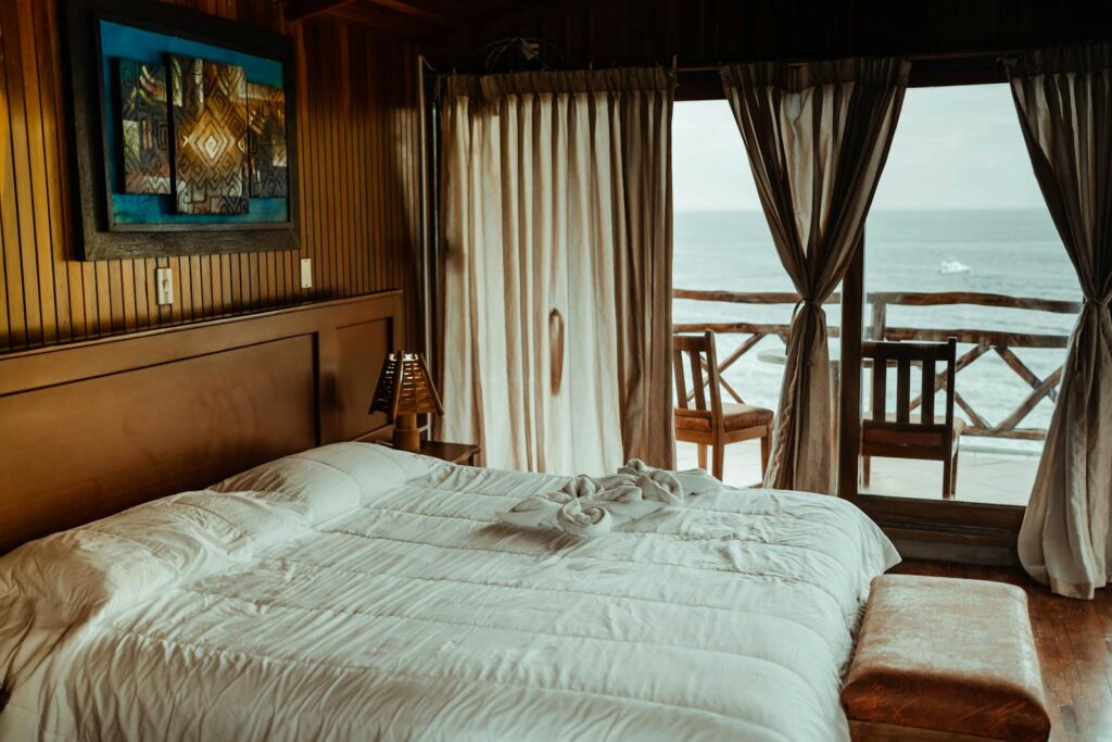 Luxurious seaside bedroom featuring a plush bed, elegant decor, and stunning ocean view for a serene escape.