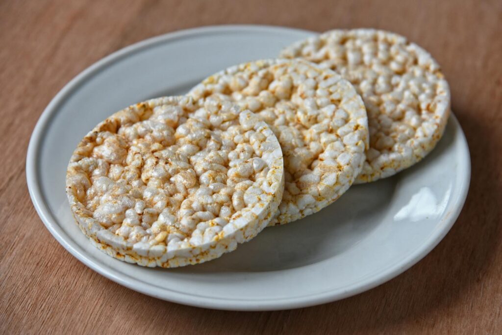 A detailed close-up of three puffed rice cakes on a white plate, perfect for food photography.
