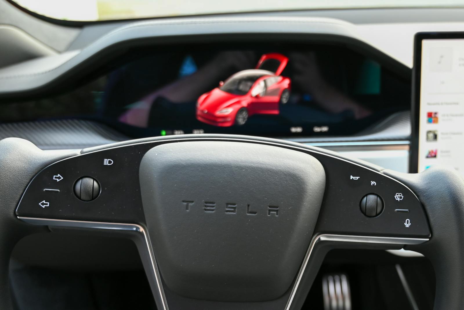 Close-up of a modern car's dashboard featuring a steering wheel and digital screen display.
