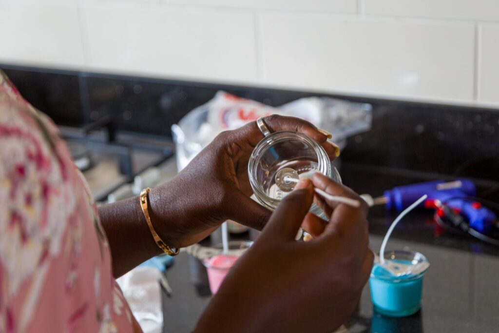 Close-up of aromatic candle crafting by an adult in a modern kitchen setting.