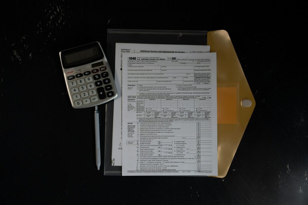 Calculator and papers in a folder on a dark surface