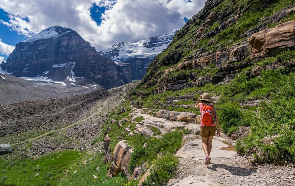 Explore nature's beauty with a hiker on a scenic mountain trail under clear skies.