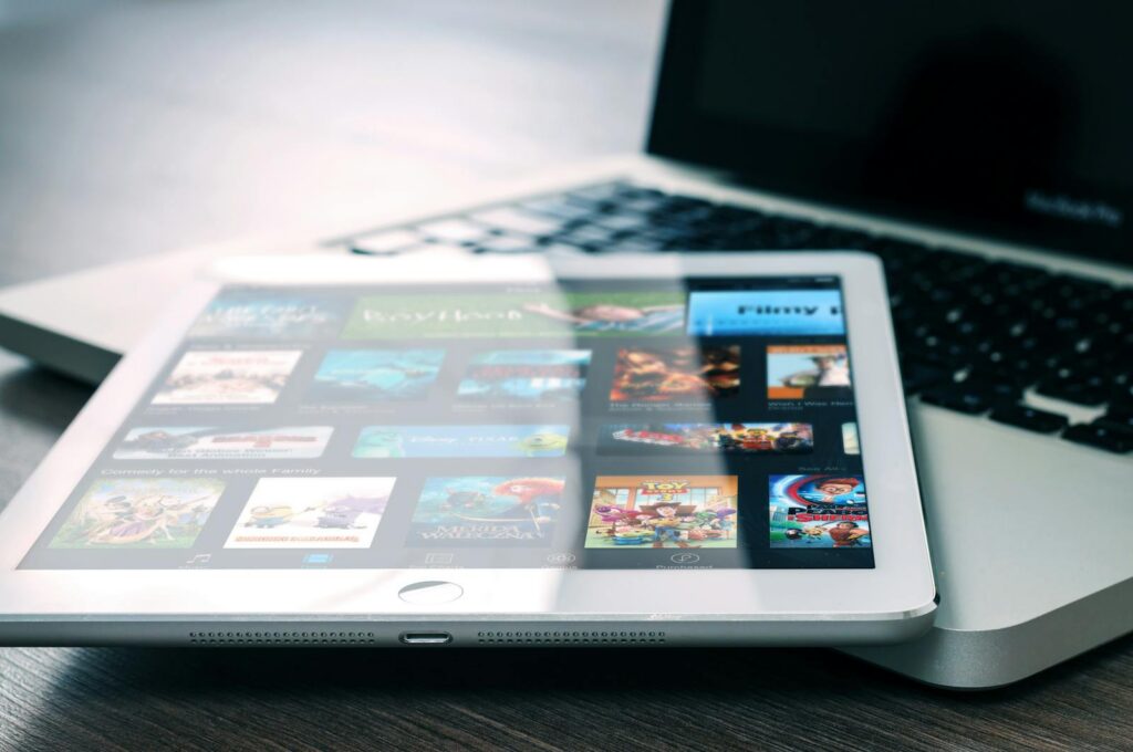 Tablet displaying streaming services on a laptop, illustrating digital entertainment setup.