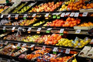 Colorful assortment of fresh fruits neatly arranged on supermarket shelves, ideal for healthy eating themes.
